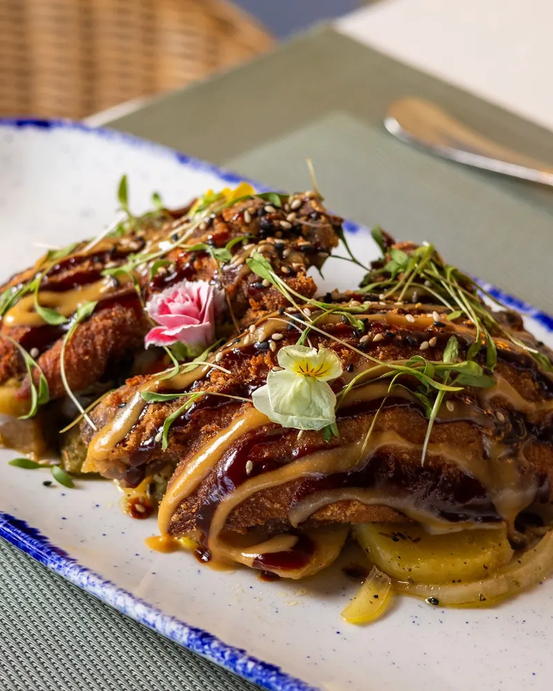 A glazed main course with fresh herbs and flowers