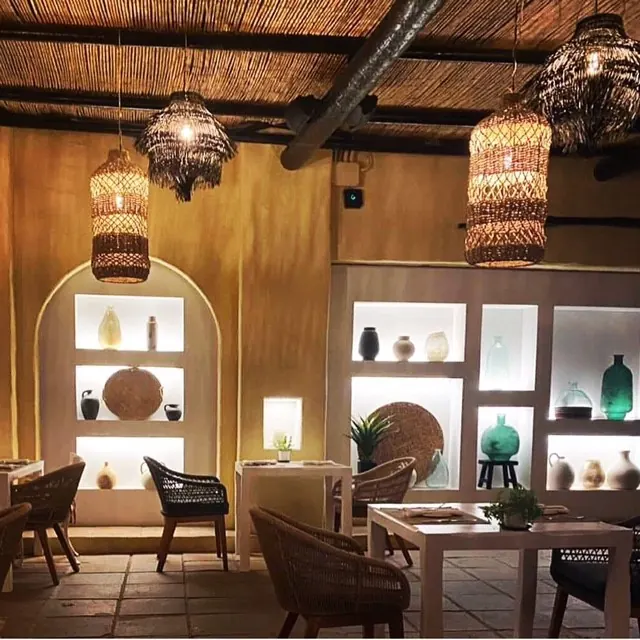 Woven lamps glowing over the dining room at night