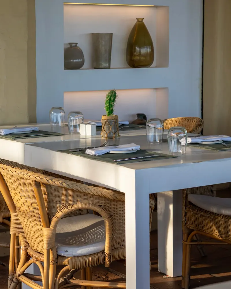 A table beside niches with vases and a cactus