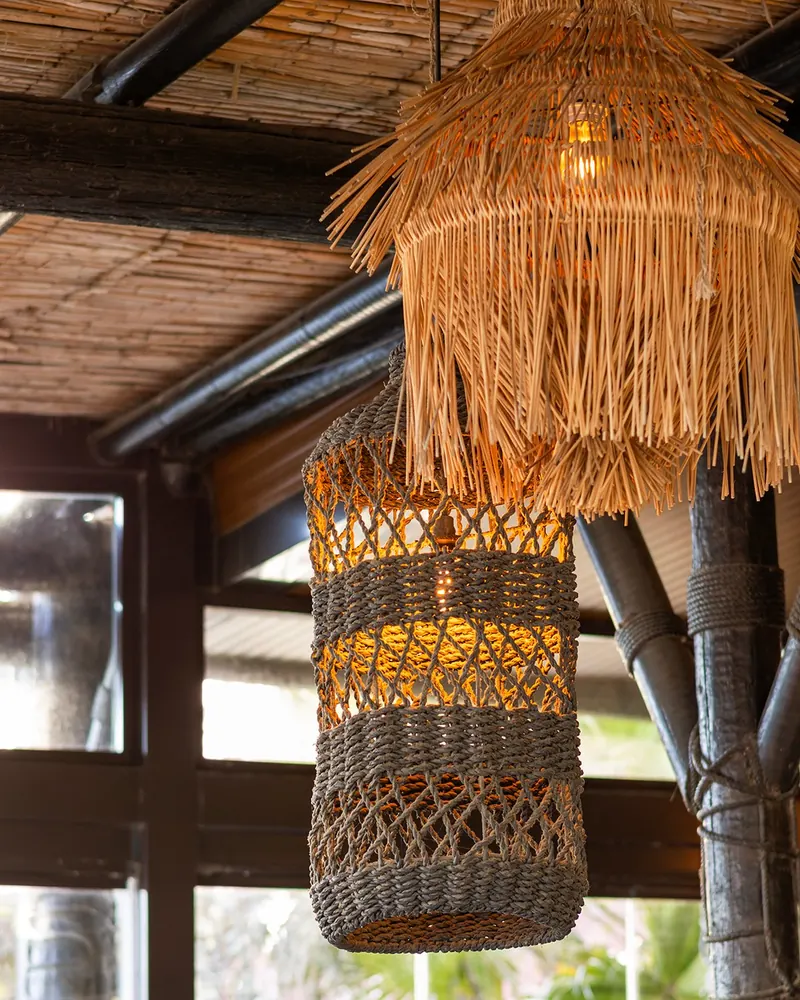 Woven rattan pendant lamps under a reed ceiling